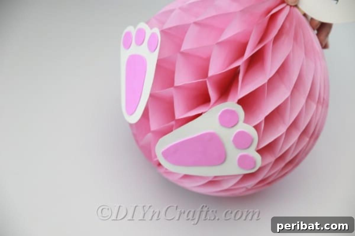 Craft an Adorable Easter Bunny from a Repurposed Party Ball 18 Glue the completed feet onto the base of the honeycomb ball.