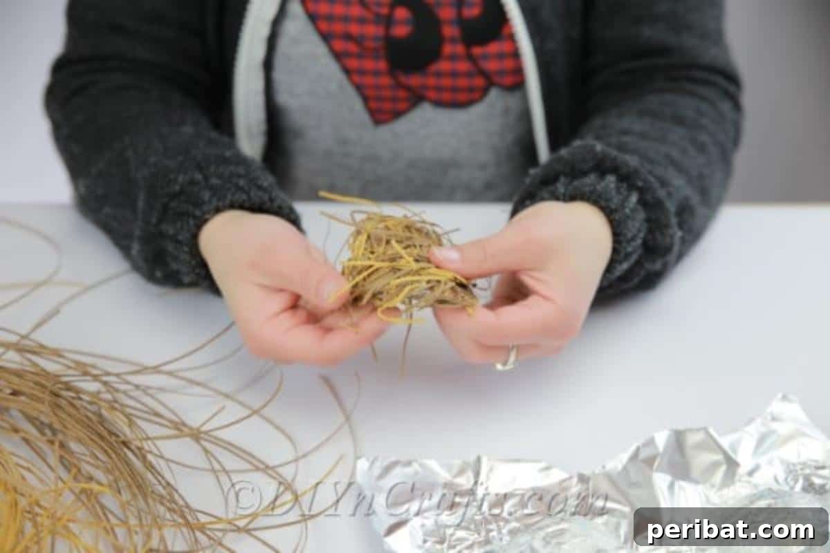 Craft a Realistic Bird Nest for Easter Treats 8 Placing shredded paper strips onto the glue-covered aluminum foil mold