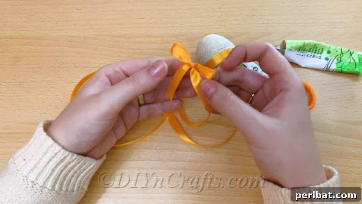 Handcrafted Rustic Glam Easter Eggs 11 Attaching a decorative ribbon around the middle of the glitter and twine Easter egg with glue