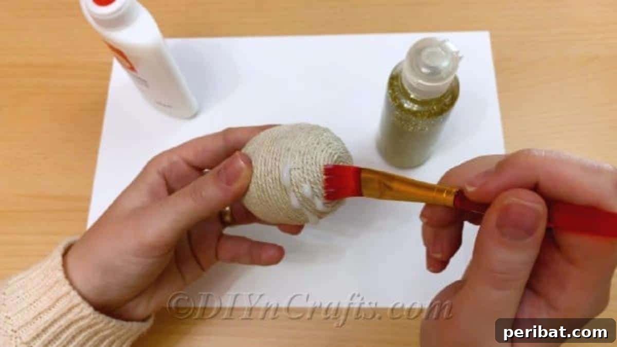 Handcrafted Rustic Glam Easter Eggs 8 Applying a generous layer of glue to the bottom section of the twine-covered egg for glitter