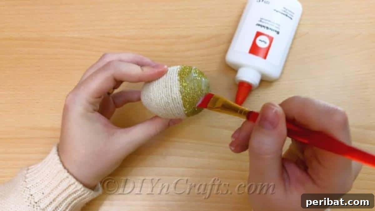 Handcrafted Rustic Glam Easter Eggs 10 Applying a top coat of glue over the dried glitter to seal it, smoothing with a paintbrush