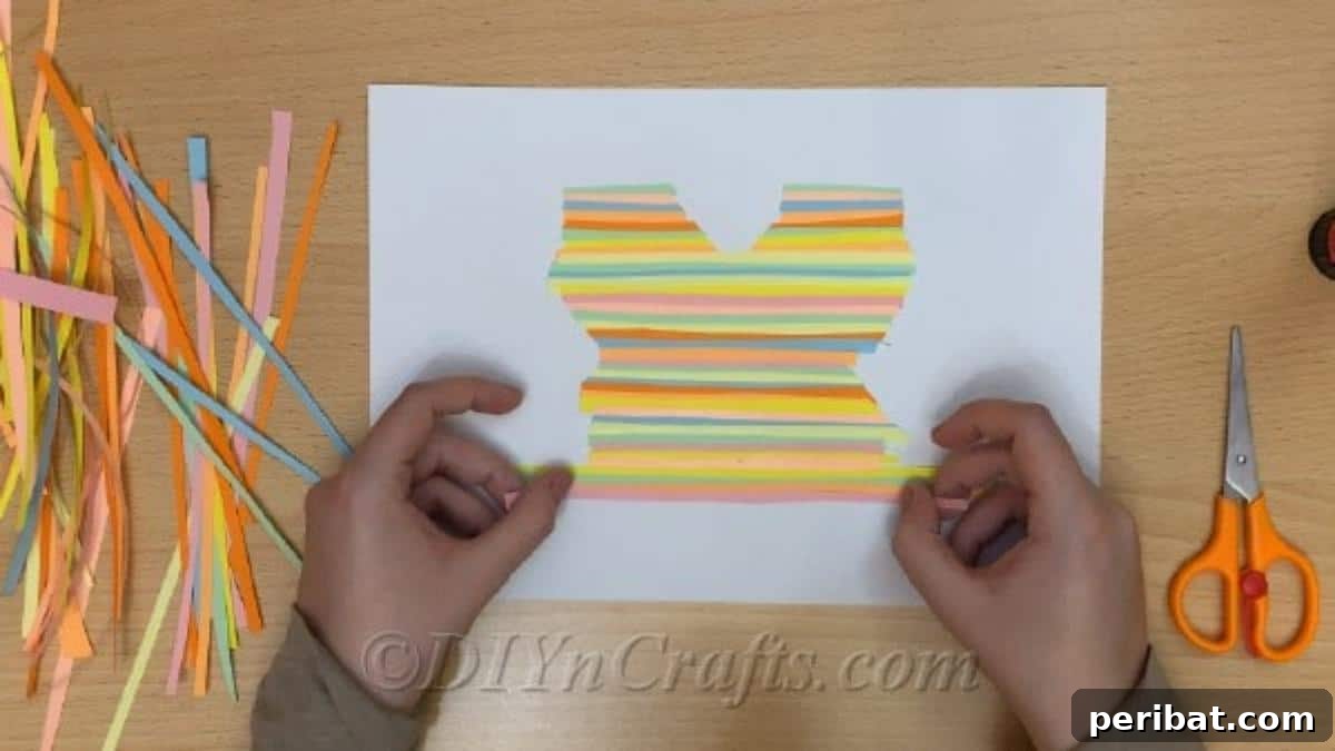 Springtime Flutter: Colorful Paper Butterflies for Little Hands 6 A white paper sheet completely covered with a mosaic of glued colorful strips, ready for the butterfly template.