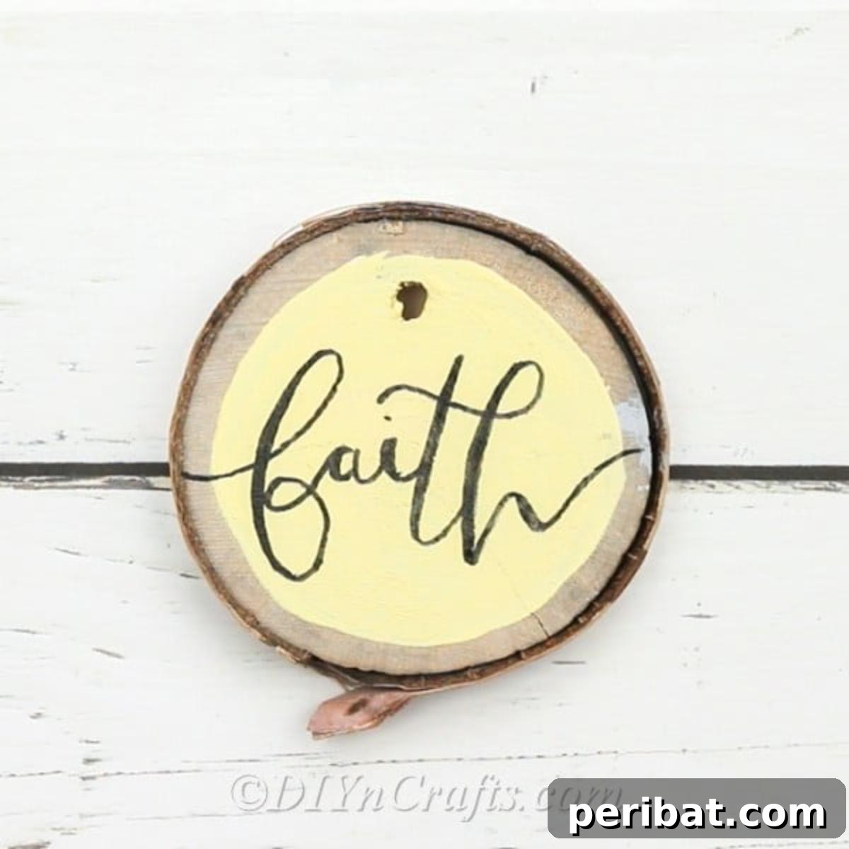 Farmhouse Hand Lettered Wood Slice Easter Decorations 12 Close-up of a hand-lettered wood slice ornament with the word 'Faith' in a graceful script, ready for display
