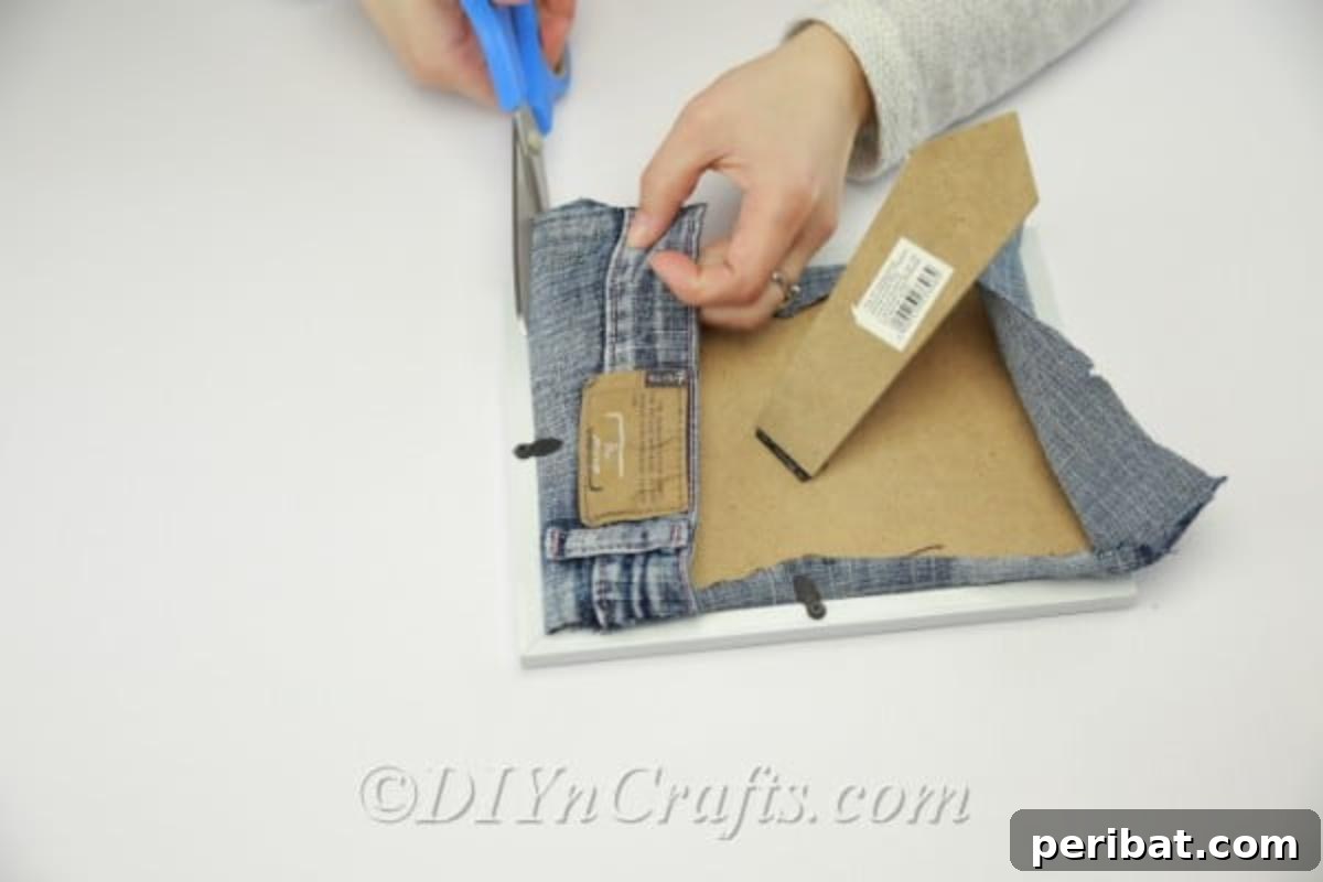 Detailed instruction on fitting the denim pocket inside a picture frame for a DIY organizer