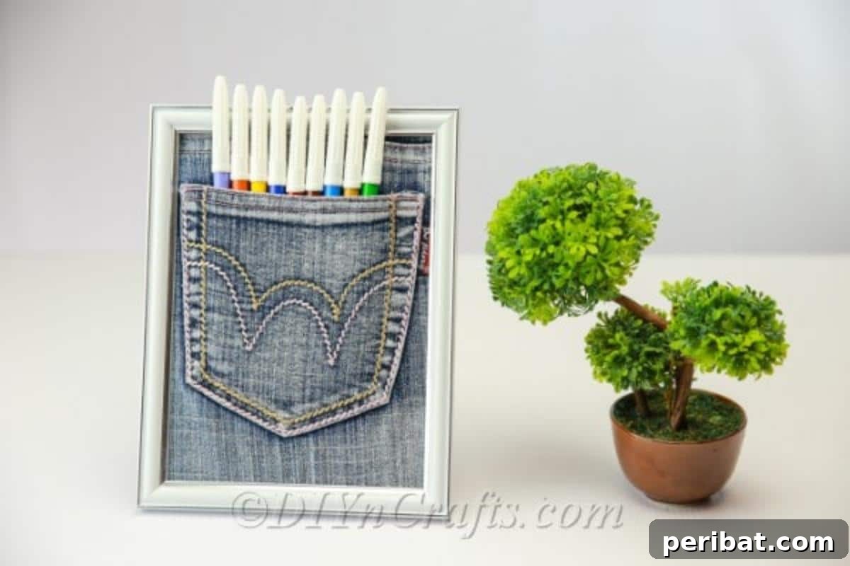Finished denim pen pocket organizer next to a green plant on a desk