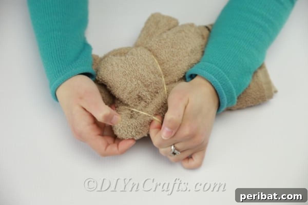 Craft a Cuddly Washcloth Bear 12 Using small rubber bands to create teddy bear ears for the washcloth craft