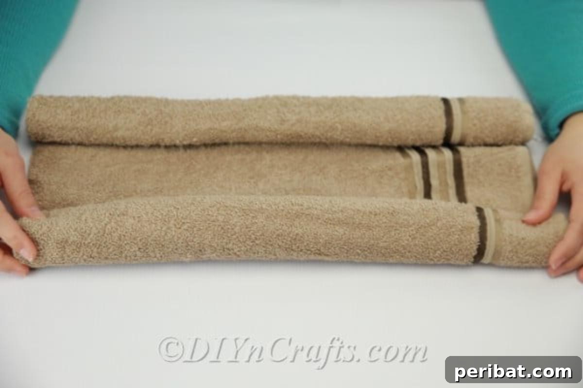 Craft a Cuddly Washcloth Bear 8 Rolling washcloth to make the teddy bear body, showing the first roll complete