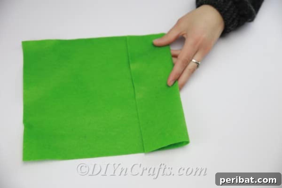 Cutting green felt into leaf shapes to complement the DIY fabric flowers.