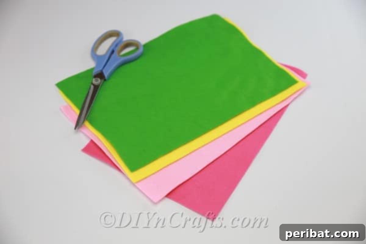 Essential supplies laid out: felt fabric, sharp scissors, and a hot glue gun for DIY fabric flowers.