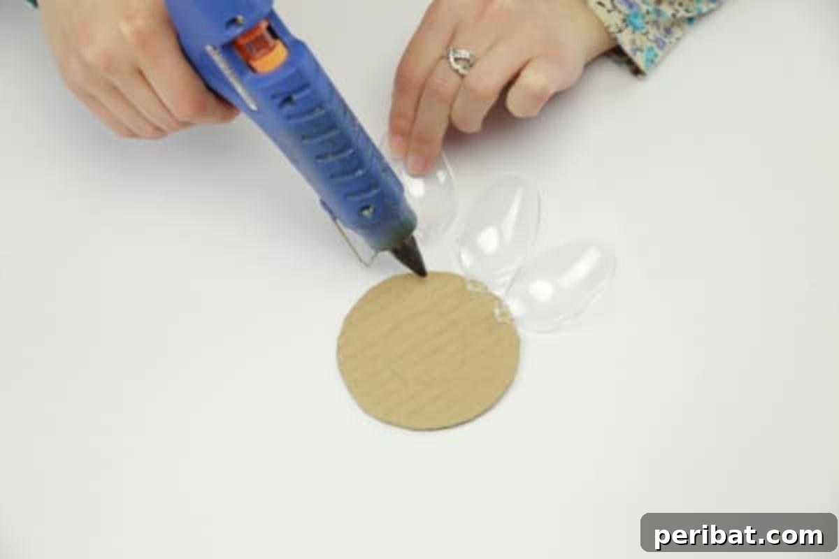 Gluing plastic spoon heads onto the outer edge of the cardboard circle