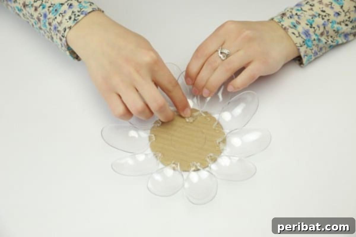 Gluing plastic spoon heads onto the inner section of the cardboard circle