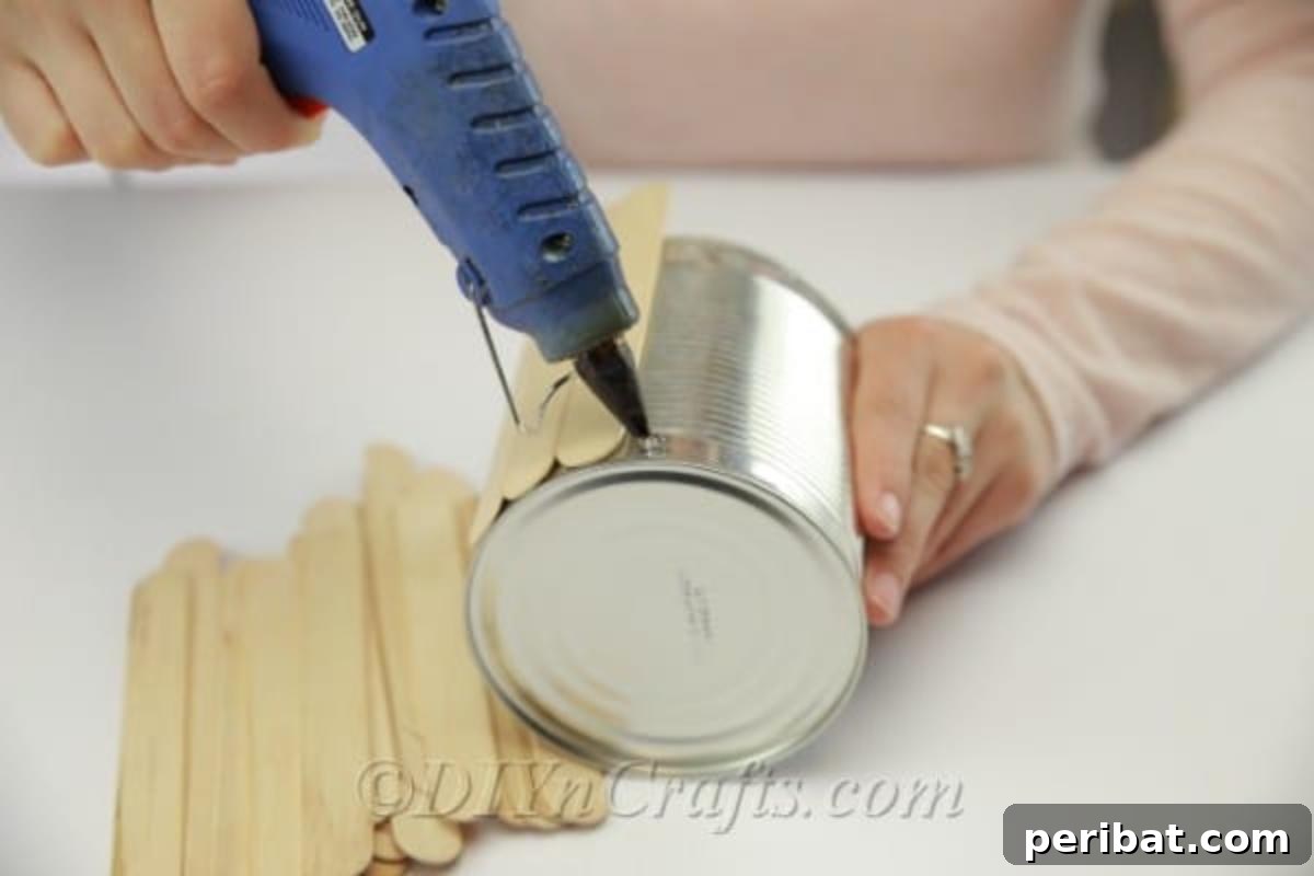Stick-tacular Creations: 3 Crafts for Every Generation 19 Gluing the first popsicle sticks onto the outside of an empty can