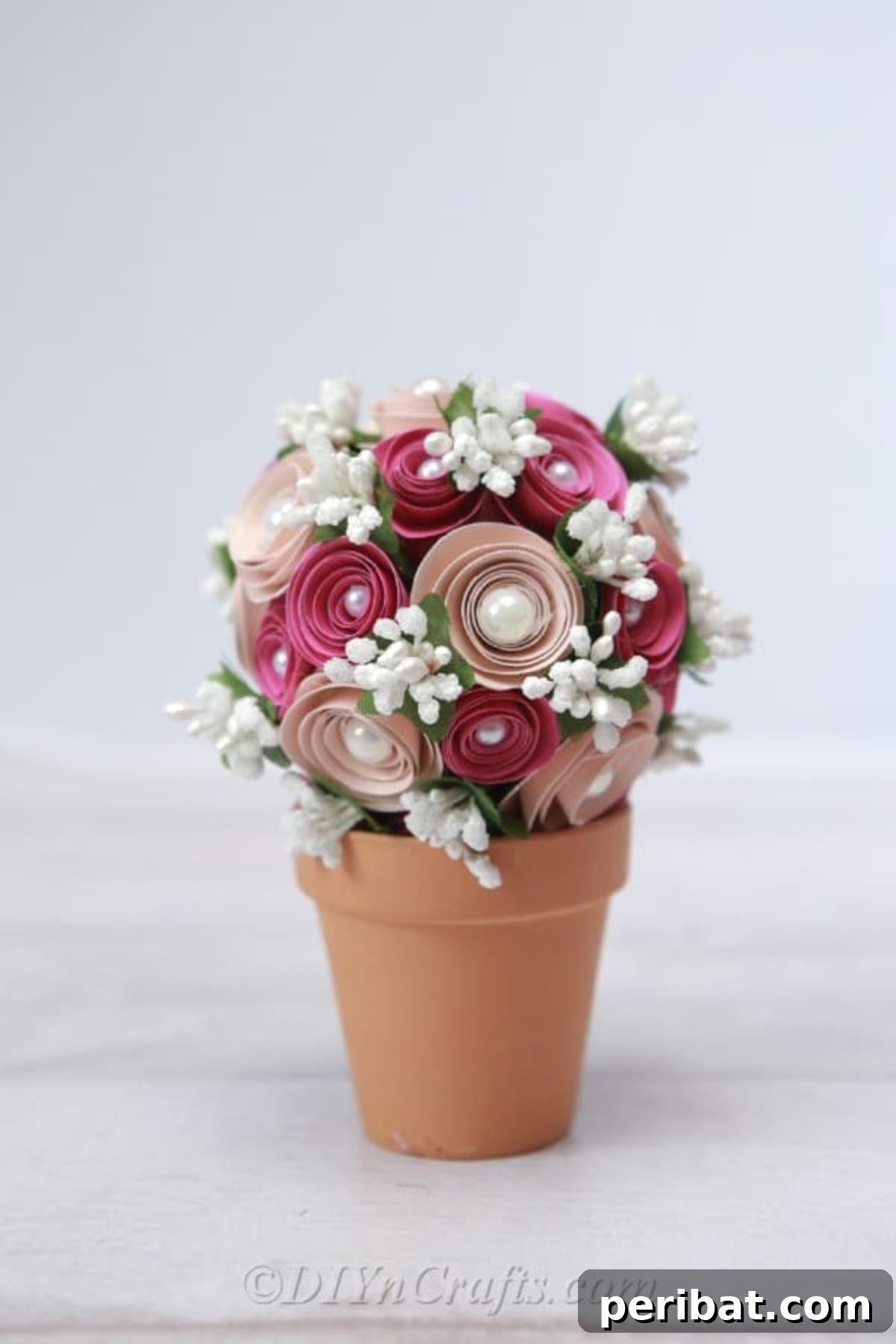 Elegantly crafted paper flower ball resting in a decorative planter, perfect for sophisticated home decor.