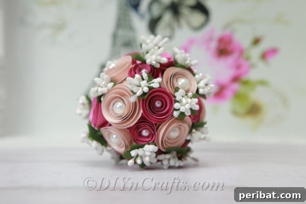 A beautifully finished DIY floral ball, adorned with intricately crafted paper flowers and delicate embellishments, presented as a centerpiece.