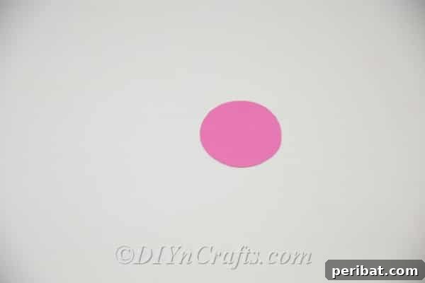 A precisely cut circular piece of vibrant colored paper, ready for the next crafting step.