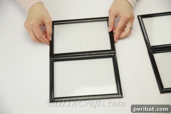 Two smaller picture frames being glued side by side to form one section of the greenhouse roof.