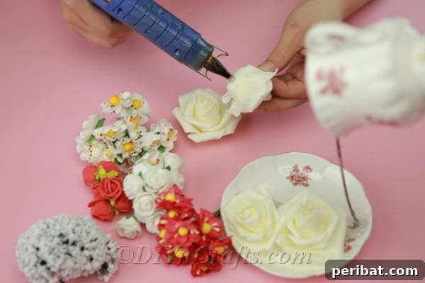 Craft a Magical Floating Teacup Ornament 11 Starting to glue artificial flowers onto the wire and saucer of the teacup craft