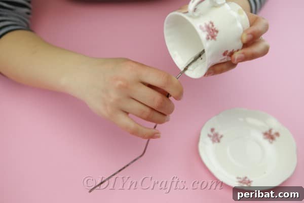 Craft a Magical Floating Teacup Ornament 8 Applying hot glue to attach one end of the bent wire inside the teacup