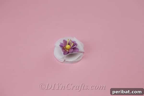 Decorating the center of a newly formed fabric flower with delicate pearls, adding a touch of elegance and completeness to the design.