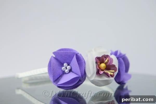 The finished DIY flower headband, featuring an elegant arrangement of purple and white fabric flowers, ready to be worn.