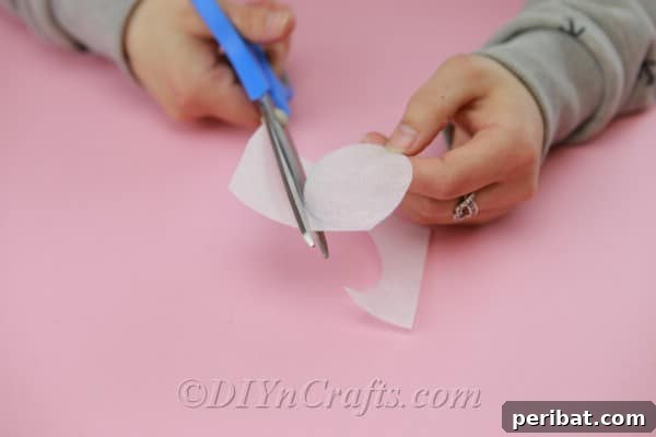 Five white fabric circles arranged to show how one will serve as the base, and the other four as petals for a single flower.