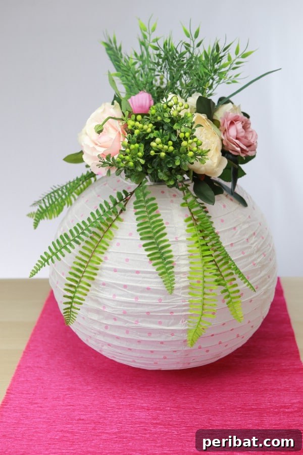 Create a Glowing Floral Lantern Centerpiece 3 A close-up view of the completed DIY paper lantern centerpiece, showcasing a rich assortment of flowers in various colors and sizes, nestled within the elegant lantern structure.