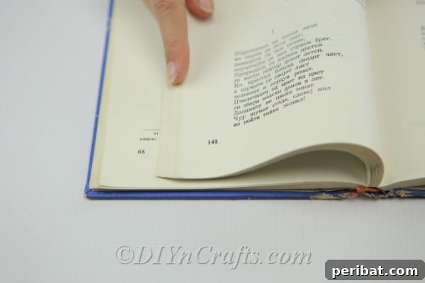 Close-up view of a book page with two pencil marks indicating where the folds will be made.