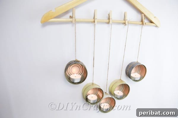 Transform Tuna Cans into Pretty Tealight Holders 11 Hanging tuna can candle holder, showcasing the completed DIY project with lit candles.