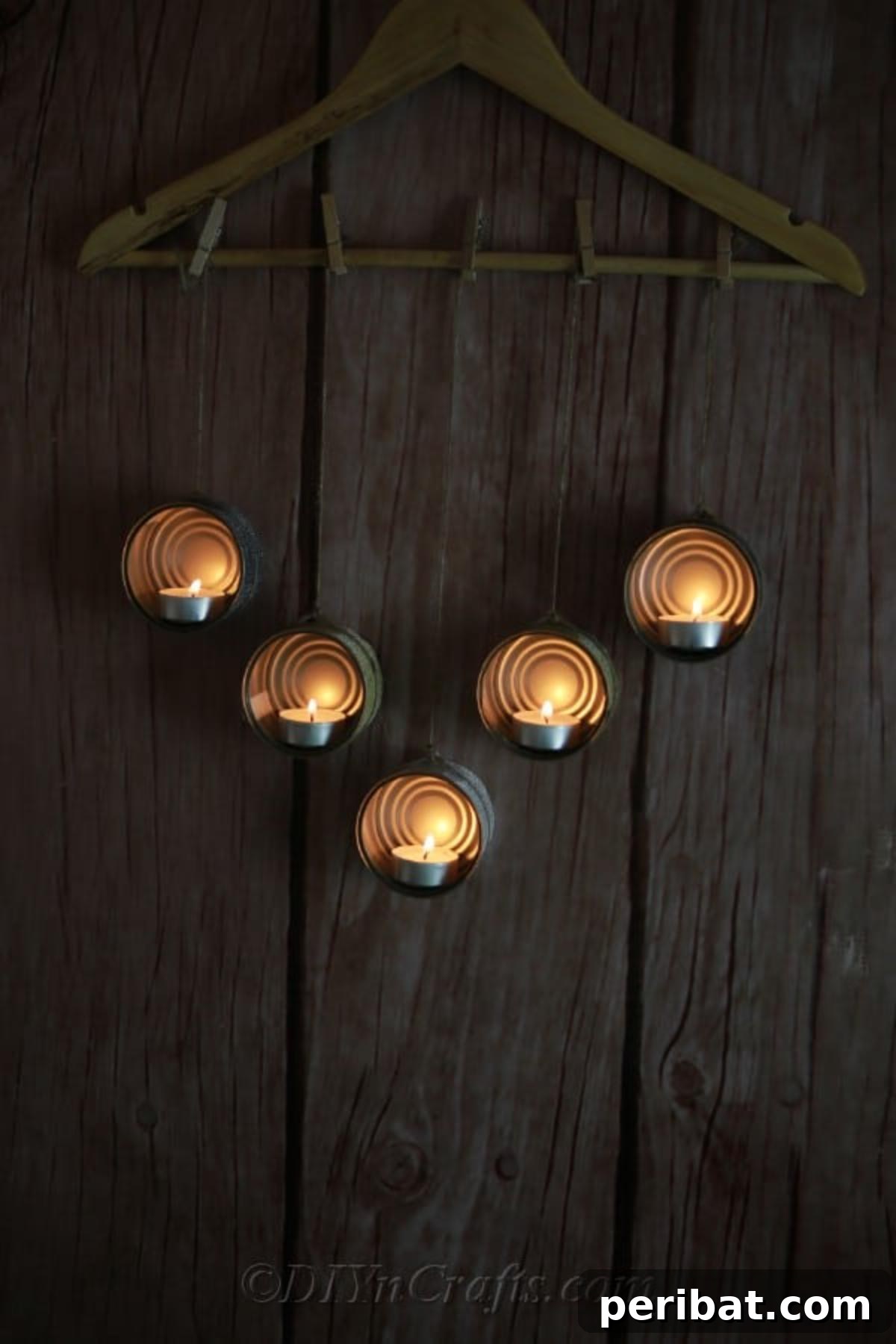 Transform Tuna Cans into Pretty Tealight Holders 4 Tuna cans turned into candleholders and hanging from a wooden hanger, ready for display.