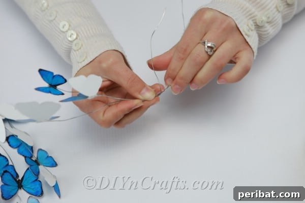 Crafting an Enchanting Butterfly Jar Terrarium 12 A blue paper butterfly being gently folded in half to create a realistic flying effect.