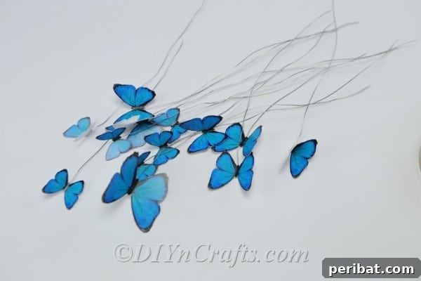 Crafting an Enchanting Butterfly Jar Terrarium 13 Several wired and glued paper butterflies, some folded, some flat, ready for arrangement.