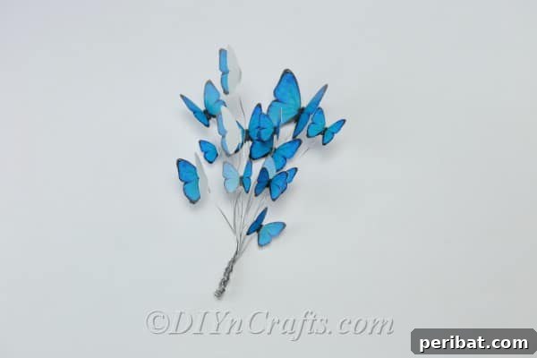 Crafting an Enchanting Butterfly Jar Terrarium 14 Craft wire with blue paper butterflies attached, bundled together for mounting.