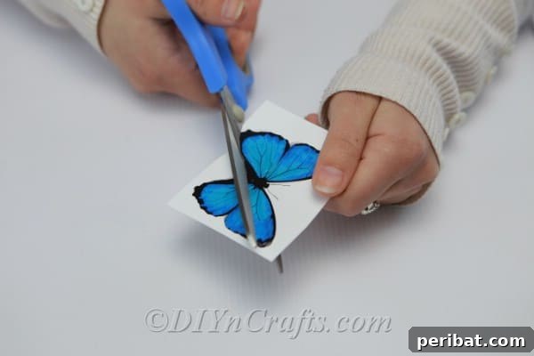 Crafting an Enchanting Butterfly Jar Terrarium 8 Carefully cut out blue paper butterflies, preparing them for the DIY terrarium project.