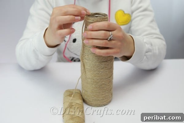 The final step of finishing the rope covering on a bottle, showing the top edge neatly secured with glue.