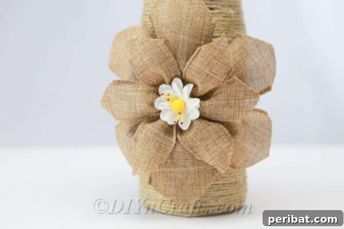 Rope Wrapped Bottles for Rustic Charm 3 Rope-covered bottle vase featuring a decorative burlap flower, showcasing a simple yet elegant rustic embellishment.