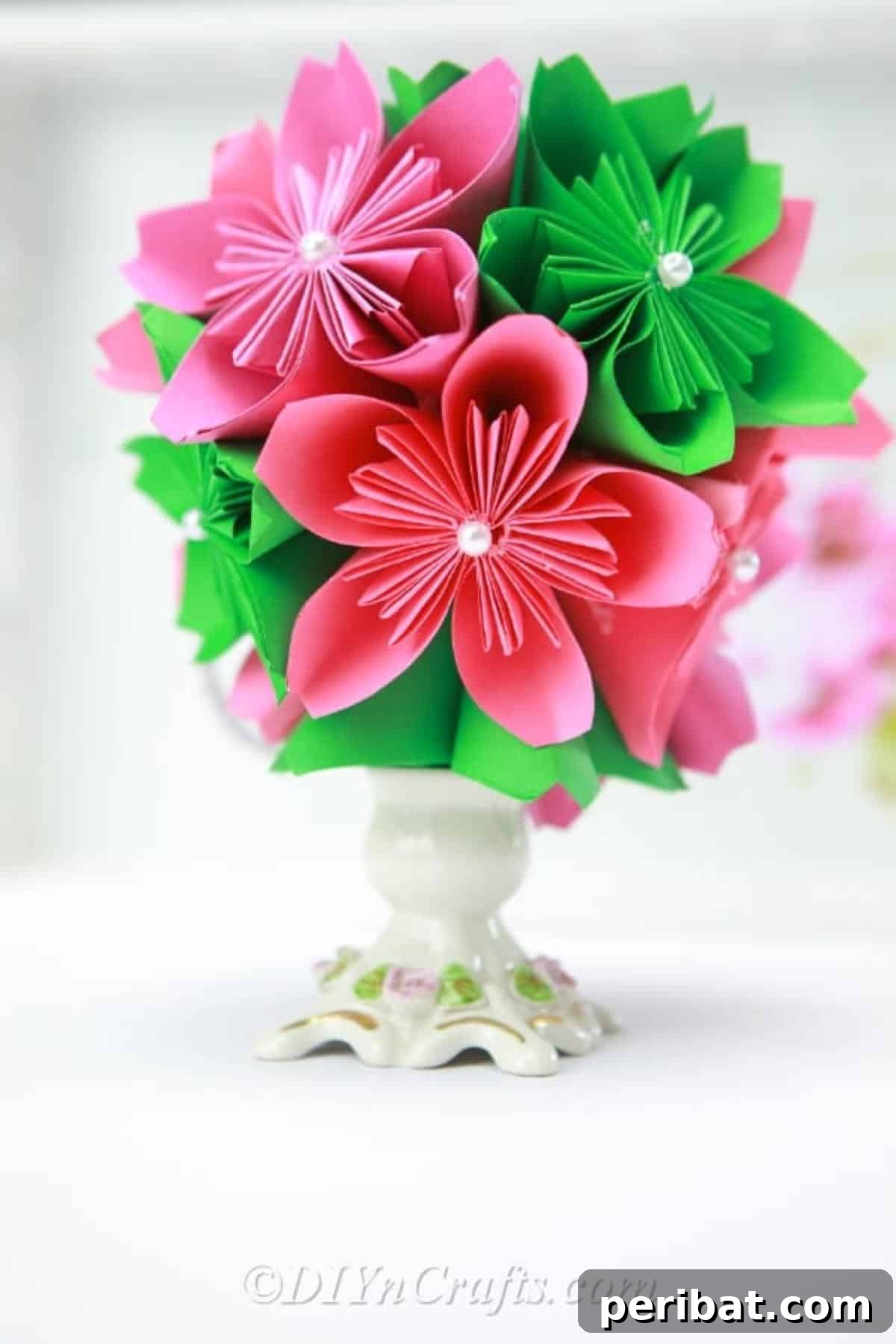 Close-up image of a delicately crafted paper ball flower in a vase, emphasizing texture and detail