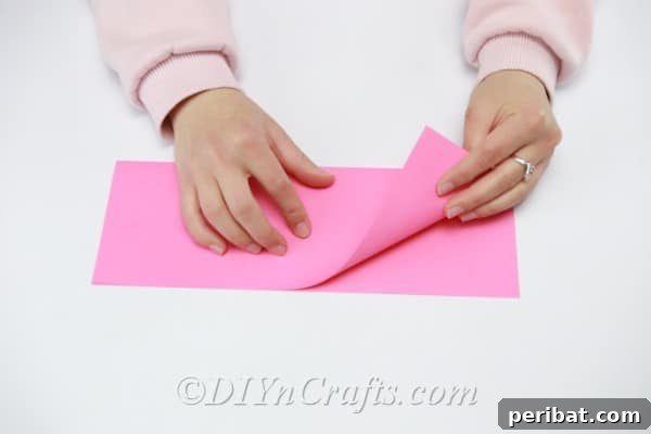 Stack of pink paper sheets, ready to be cut and folded into flower petals