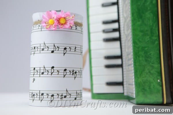 A finished music jar adorned with pink artificial flowers, ready for display