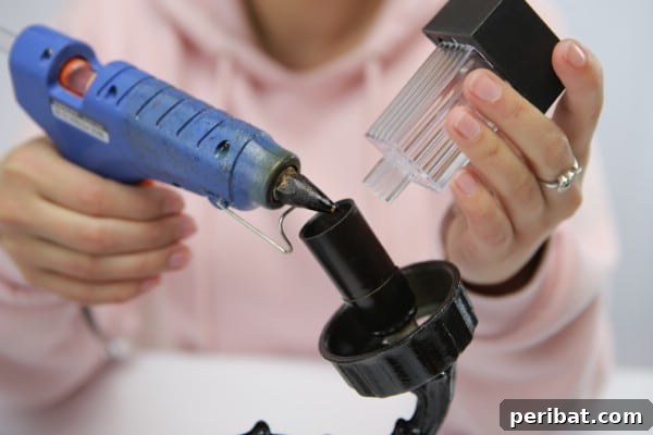 Applying super glue to attach solar lights onto an old chandelier fixture