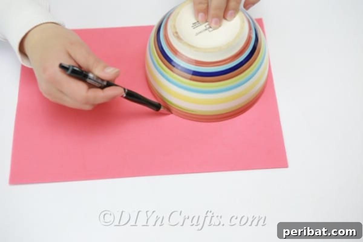 A pencil tracing the rim of a bowl onto a sheet of craft foam to create a perfect circular shape.