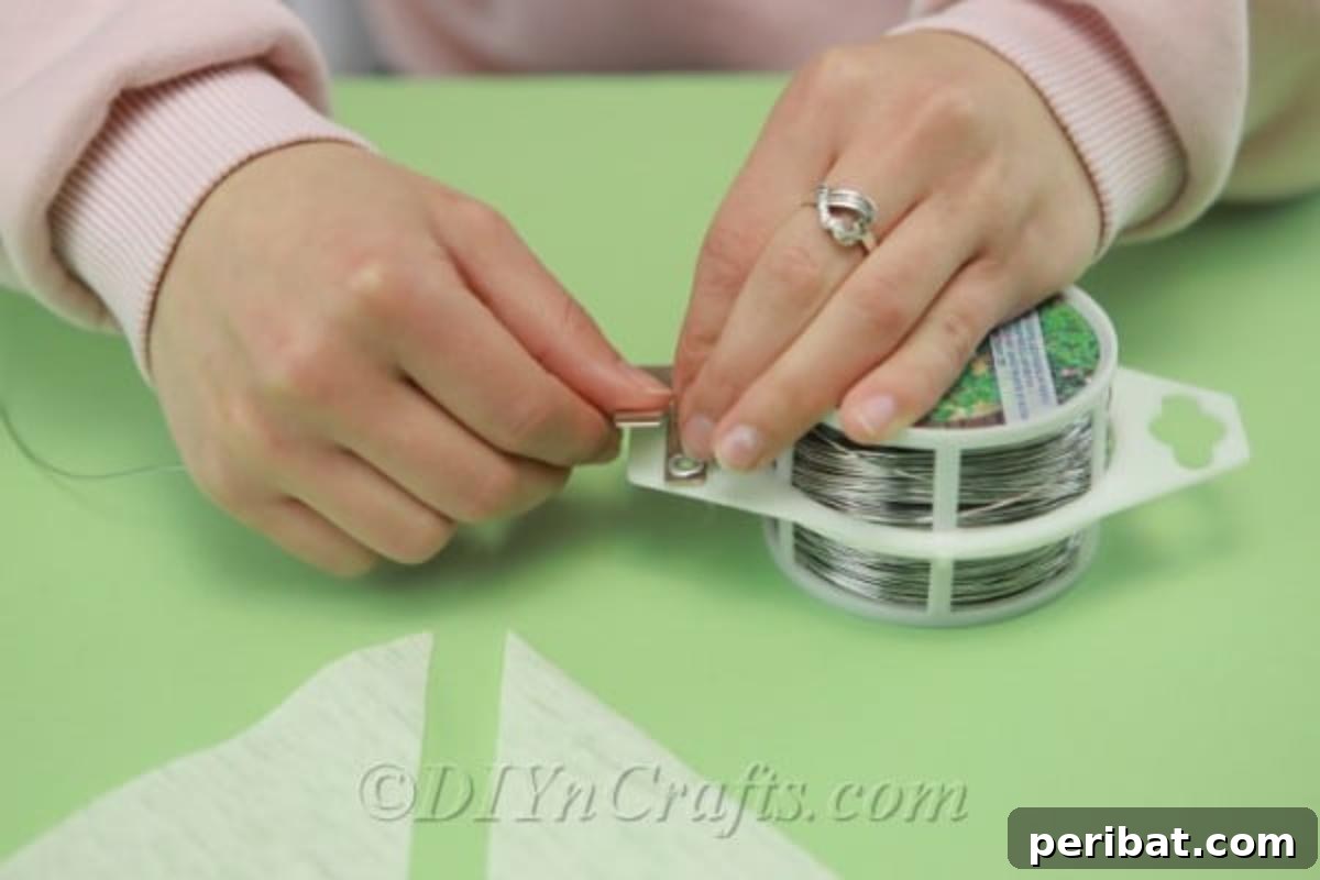 A floral wire is being measured precisely against a ruler or piece of paper, ensuring the correct length for crafting.
