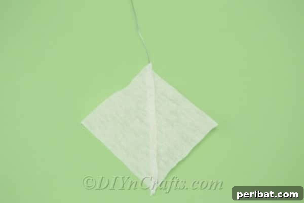 Two pieces of tissue paper, with a floral wire in between, are carefully glued together along their edges to form a petal.