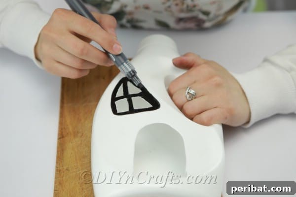 Darkening openings with a marker to enhance definition and give the fairy house a finished look