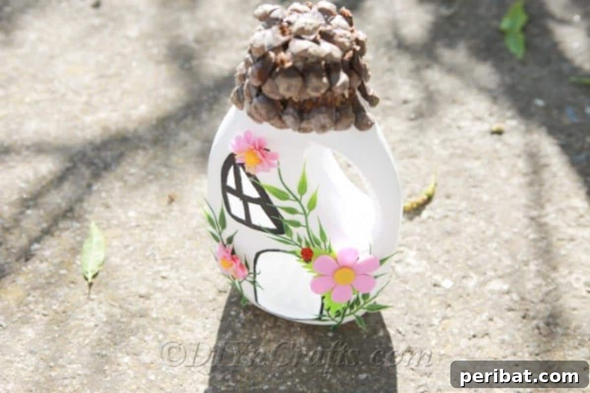 Top view of an upcycled fairy house on pavement, showcasing its unique design and pinecone roof