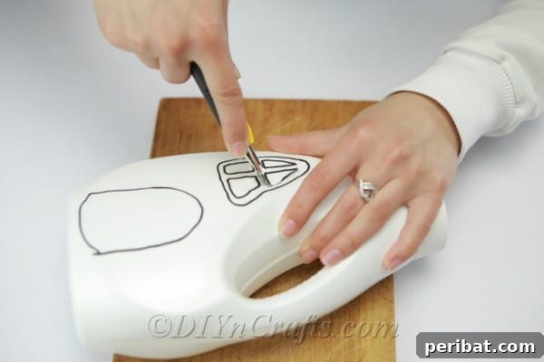 Cutting windows and doors out of bottle with a craft knife, demonstrating careful precision