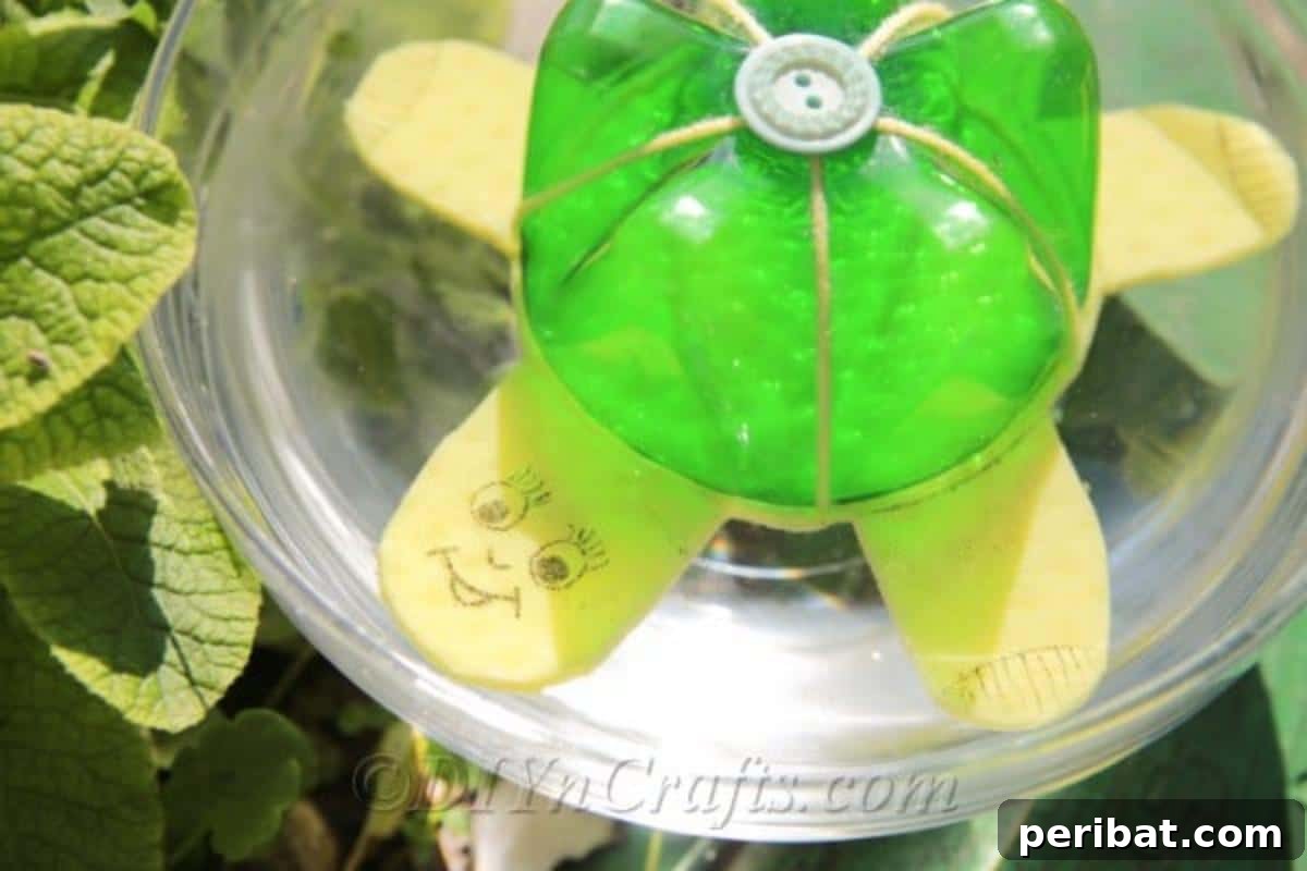 A close-up view of the half-finished plastic bottle turtle, resting in a bowl of water, highlighting its clever upcycled design.