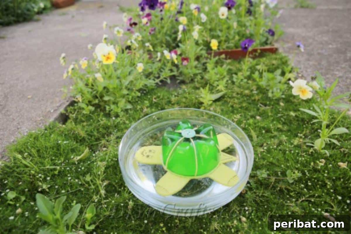 A charming plastic bottle turtle craft, painted green and yellow, sits on a stone patio, ready to be a delightful garden decoration.