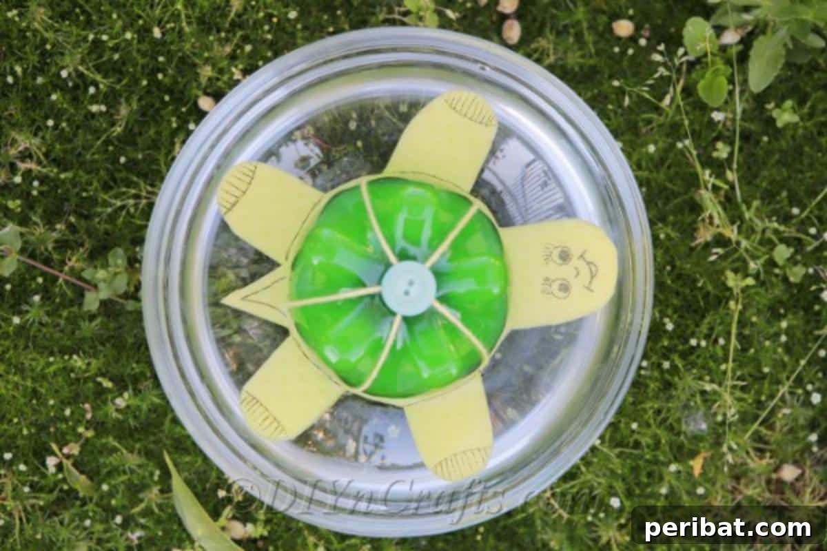 A charming, handcrafted plastic bottle turtle, painted green and yellow, floats serenely in a clear bowl of water, viewed from above.