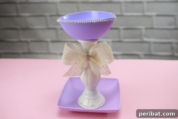 Upcycle Plates into a Stylish Two-Tier Jewelry Holder 9 Purple jewelry holder with a white bow, showcasing the finished product