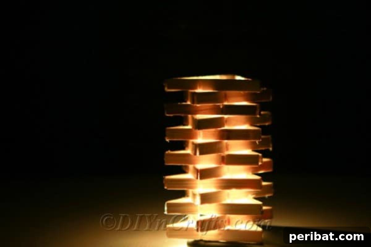 Transform Clothespins into a Stylish Lamp 3 Atmospheric shot of the clothespin lamp illuminating a dark room with a warm glow.